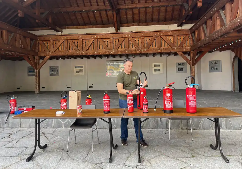 Vérification extincteurs – Morzine – Halle de l’Église Technicien MAT-SEC vérifiant des extincteurs sous la Halle de l’Église à Morzine